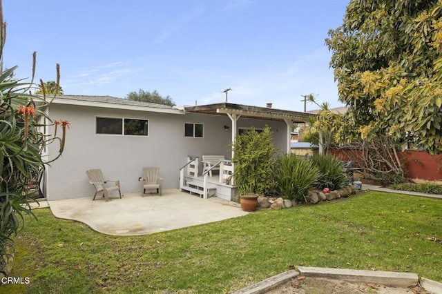 rear view of property featuring a patio area and a lawn