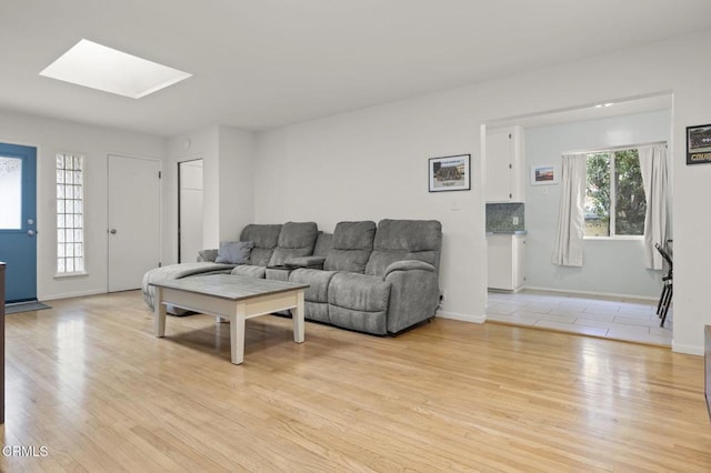 living room with a skylight and light wood-type flooring