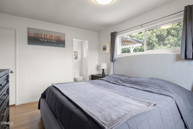 bedroom featuring ensuite bath and wood-type flooring