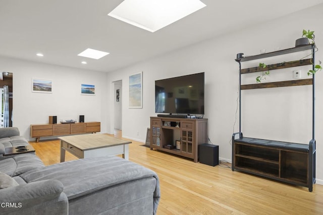 living room featuring light wood-type flooring and a skylight