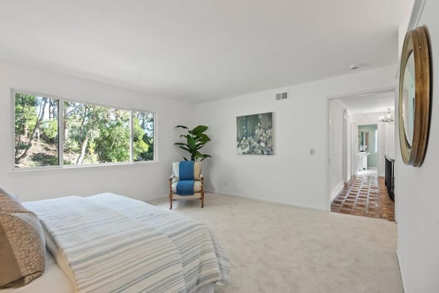 carpeted bedroom featuring fridge and an inviting chandelier