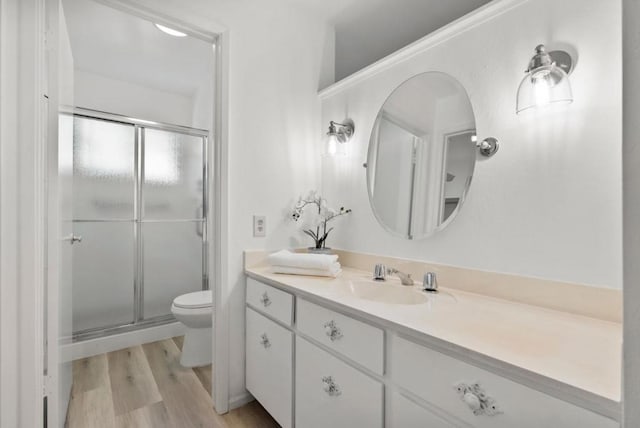 bathroom featuring vanity, toilet, hardwood / wood-style floors, and walk in shower