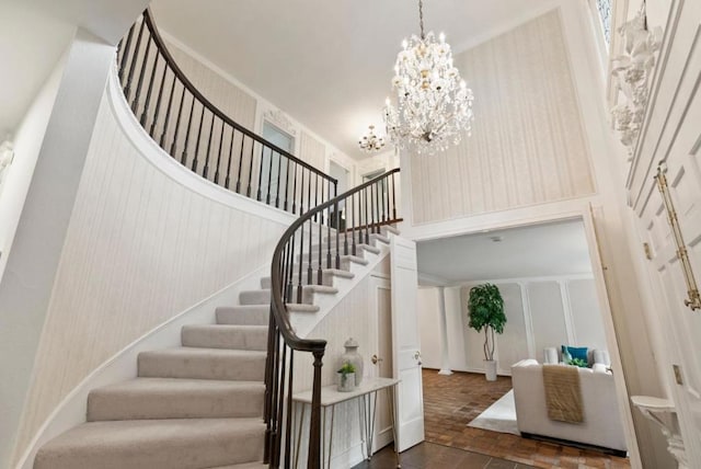 stairs with a chandelier and a high ceiling