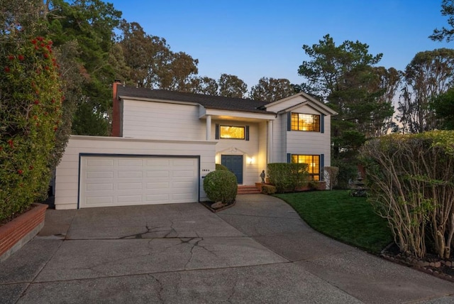 view of front of house with a garage and a lawn