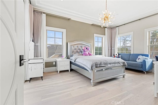 bedroom featuring ornamental molding, light hardwood / wood-style floors, and a notable chandelier