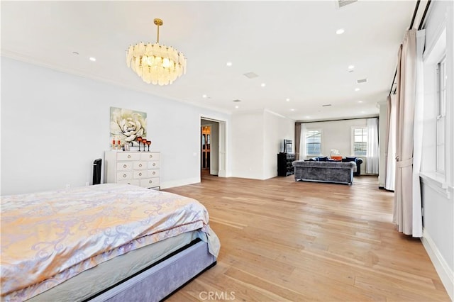 bedroom featuring a notable chandelier, ornamental molding, and light wood-type flooring