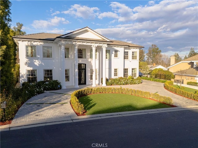 greek revival inspired property featuring a front yard