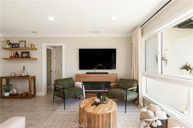 living room with crown molding and light wood-type flooring