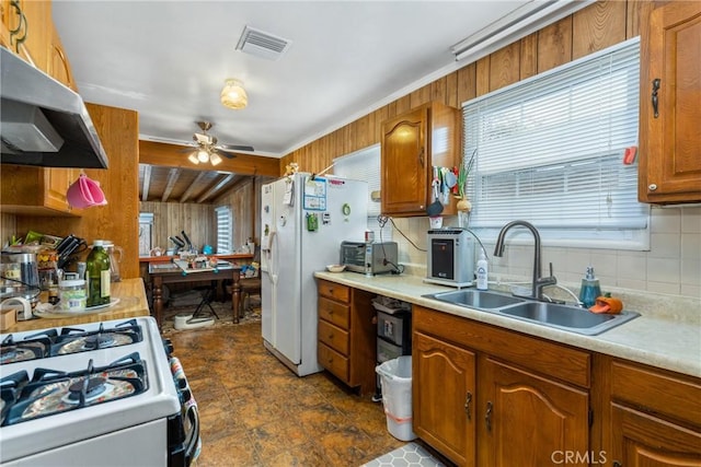 kitchen with a healthy amount of sunlight, sink, backsplash, and white appliances