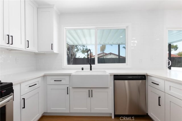 kitchen with sink, white cabinetry, light hardwood / wood-style flooring, appliances with stainless steel finishes, and decorative backsplash