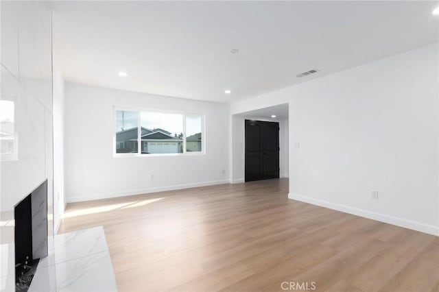 unfurnished living room with a fireplace and light hardwood / wood-style flooring