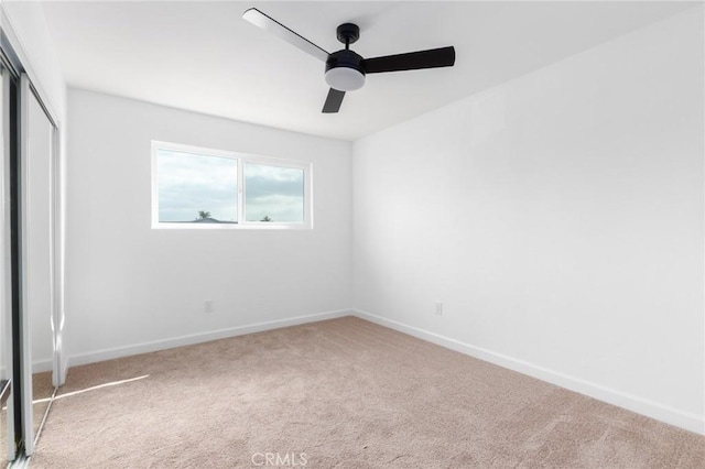 unfurnished bedroom featuring light carpet, ceiling fan, and a closet