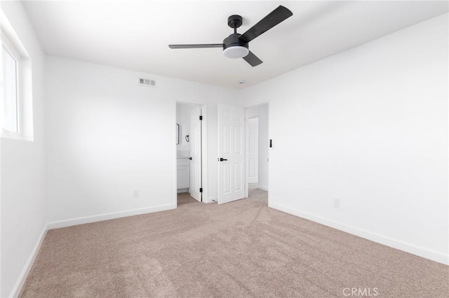 unfurnished room with light colored carpet and ceiling fan