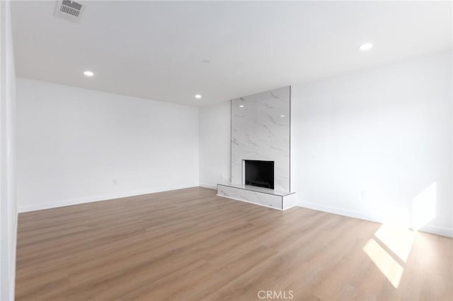 unfurnished living room with a premium fireplace and light wood-type flooring