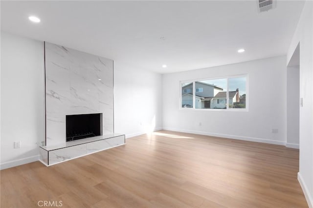 unfurnished living room with hardwood / wood-style flooring and a premium fireplace