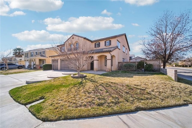 mediterranean / spanish home with a garage and a front lawn