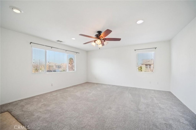 carpeted spare room featuring ceiling fan