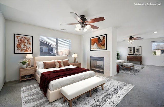 carpeted bedroom with multiple windows and ceiling fan