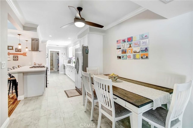 dining area with ceiling fan, ornamental molding, and sink