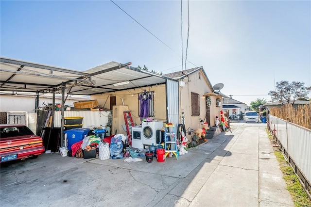 exterior space with a carport and washer / dryer