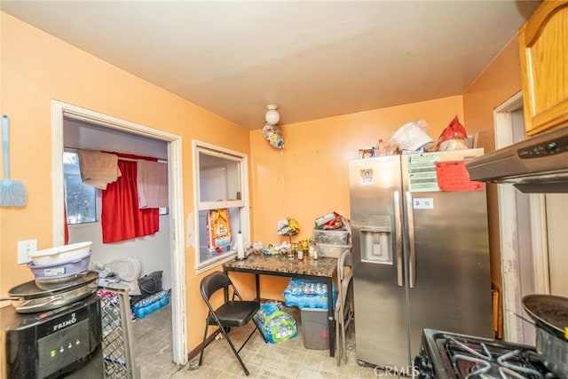 kitchen featuring range with gas stovetop and stainless steel refrigerator with ice dispenser