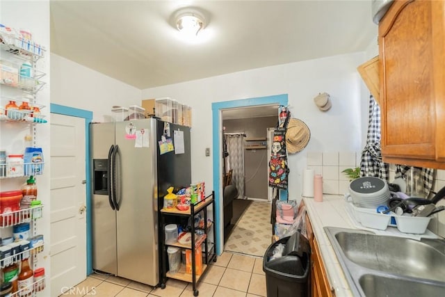 kitchen with light tile patterned flooring, sink, and stainless steel fridge with ice dispenser