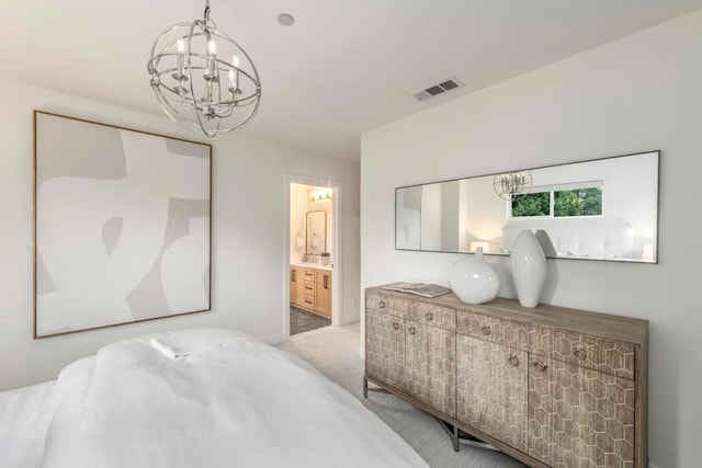 carpeted bedroom featuring a chandelier and ensuite bathroom