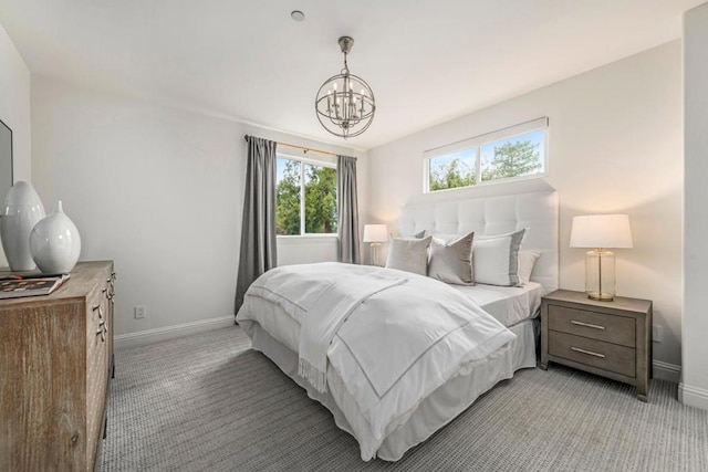 bedroom with light carpet and an inviting chandelier