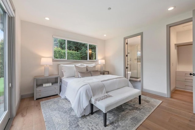 bedroom with ensuite bathroom and light hardwood / wood-style flooring