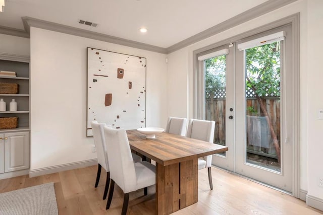 dining area with crown molding, light hardwood / wood-style flooring, and french doors