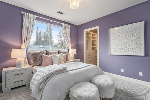 bedroom with a spacious closet and light carpet