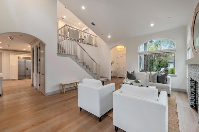 living room featuring light hardwood / wood-style flooring and a high ceiling