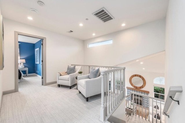 living area featuring plenty of natural light and light carpet