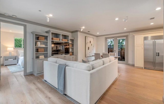 living room with plenty of natural light, ornamental molding, and light wood-type flooring