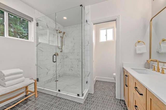 bathroom featuring vanity, a shower with shower door, and toilet