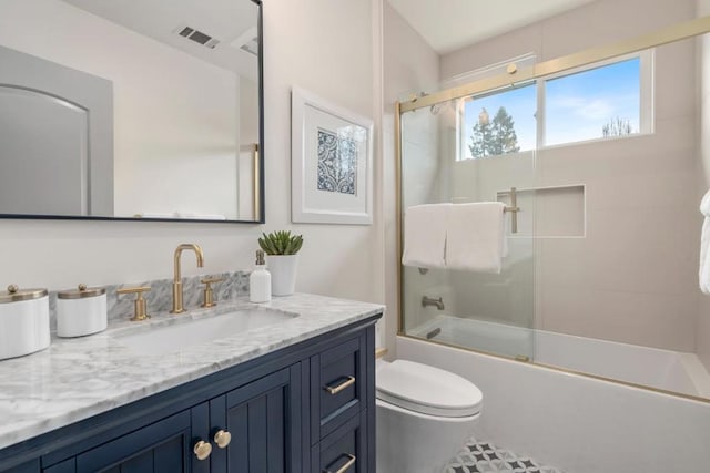 full bathroom with vanity, shower / bath combination with glass door, and toilet