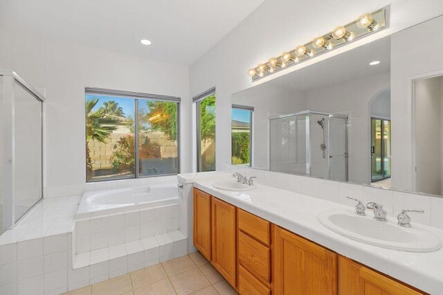 bathroom with tile patterned floors, plus walk in shower, and vanity