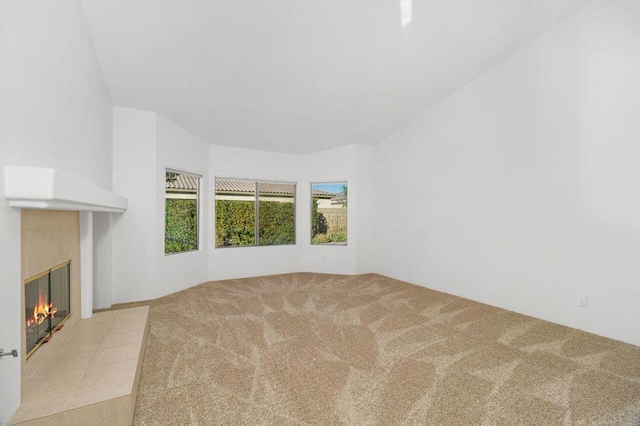 unfurnished living room featuring light colored carpet and a fireplace