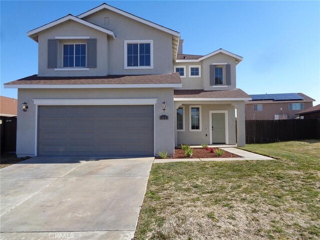 view of property featuring a garage and a front lawn