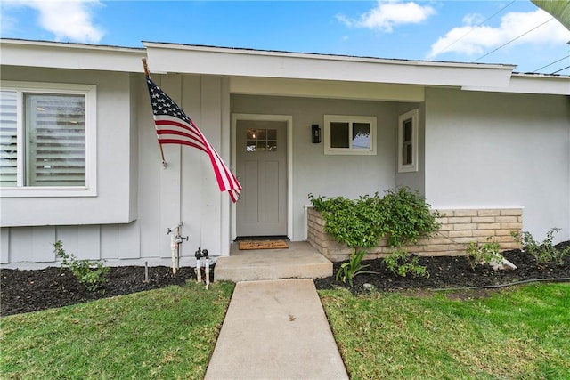 property entrance with a lawn