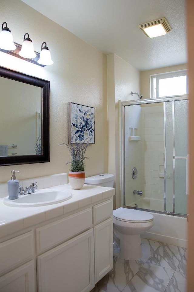 full bathroom with enclosed tub / shower combo, vanity, a textured ceiling, and toilet