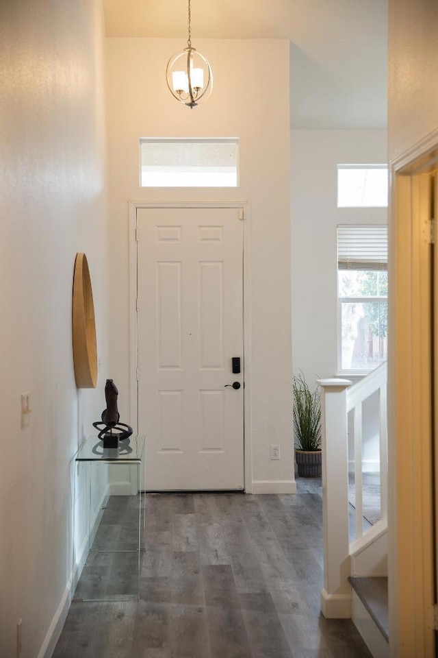 foyer entrance with dark wood-type flooring and an inviting chandelier