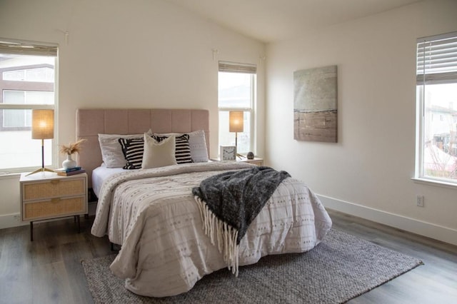 bedroom featuring multiple windows, vaulted ceiling, and dark hardwood / wood-style floors