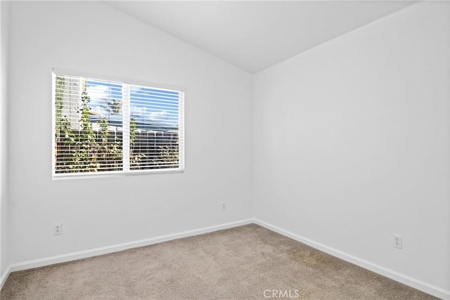 empty room featuring light colored carpet and vaulted ceiling