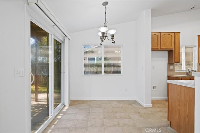 unfurnished dining area with a notable chandelier, sink, vaulted ceiling, and a wealth of natural light