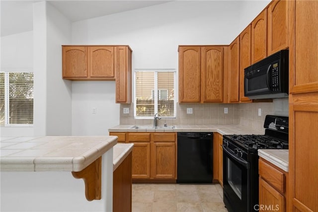 kitchen featuring sink, light tile patterned floors, black appliances, decorative backsplash, and tile countertops