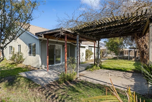 rear view of house featuring a yard, a pergola, and a patio