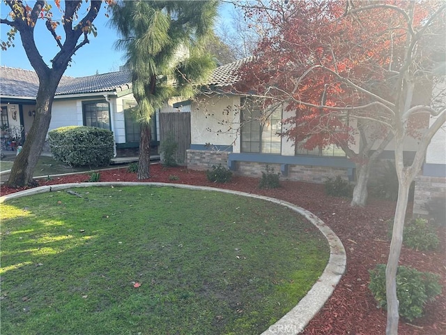view of front of home with a front lawn and a tiled roof
