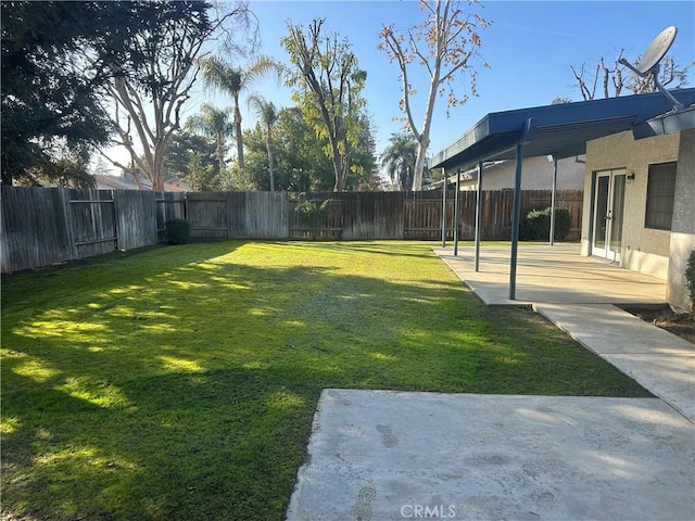 view of yard featuring french doors, a fenced backyard, and a patio area