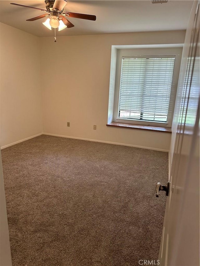carpeted empty room featuring baseboards and a ceiling fan